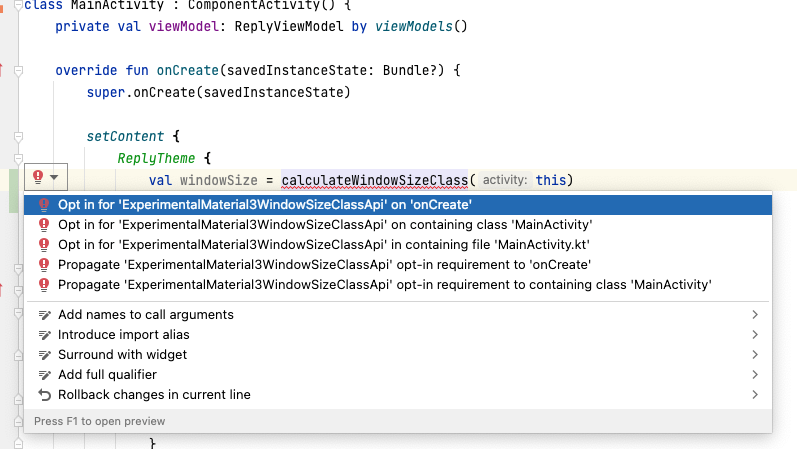 Trong mã này, dòng "val windowSize = calculateWindowSizeClass(this)" được chọn, với biểu tượng bóng đèn bên phải hiển thị ở bên trái dòng mã. Trong bóng đèn đã chọn, bạn sẽ thấy một danh sách các tuỳ chọn để xử lý lỗi, trong đó tuỳ chọn "Chọn sử dụng 'ExperimentalMaterial3WindowSizeClassApi' trên 'onCreate' được chọn.